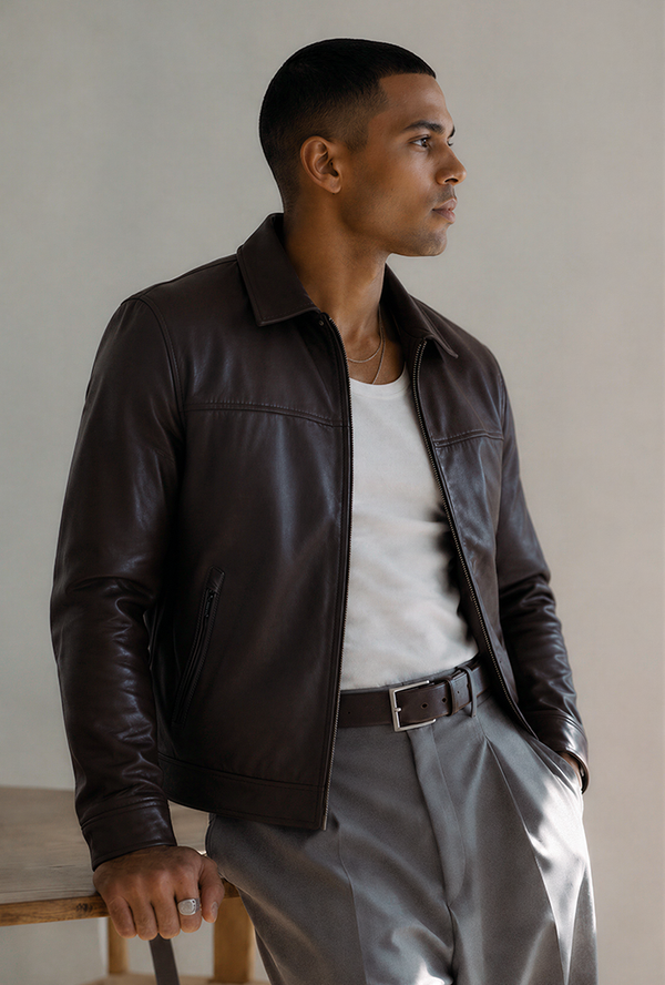 Style the jacket over a white tank with relaxed grey trousers for a modern, effortless outfit. The addition of a matching brown belt keeps the ensemble cohesive and refined.